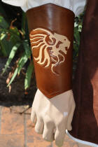 canons d'avant-bras en cuir, motif lion stylisé